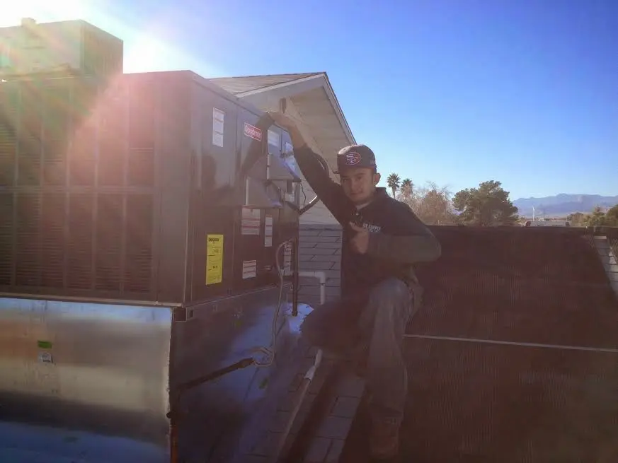HVAC technician performing Air Duct Cleaning on a rooftop unit in Smithfield